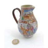 A Chinese Famille Rose jug with woven handle depicting an oriental family in a pagoda garden scene,