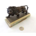 A patinated bronze lion mounted upon a brass and onyx base.