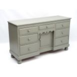 An early 20thC continental painted pine dresser base comprising a central drawer and door flanked