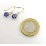 A pair of 14k gold drop earrings set with tanzanite and white stones.