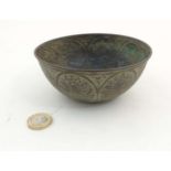 An old repousse bronze bowl with images of various deity like figures, including birds,