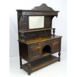 An early 20thC oak sideboard with mirrored back,