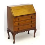 An Edwardian inlaid bureau with fall front opening to reveal pigeon holes and single short drawer