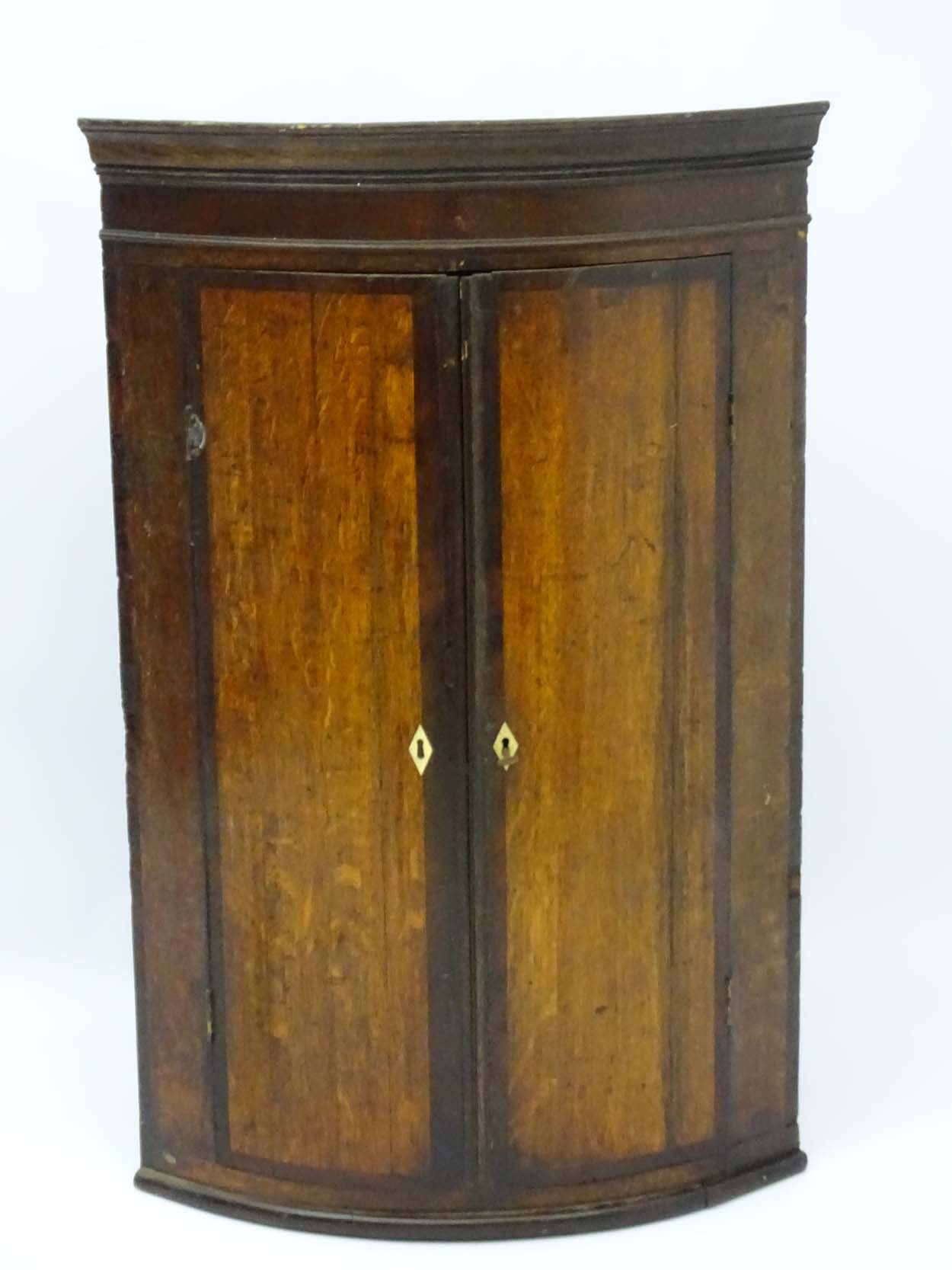 A late 18thC oak bow fronted corner cupboard with mahogany cross banded doors and mahogany frieze - Image 4 of 7