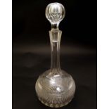 A cut glass decanter of globe / bulb form with stopper .