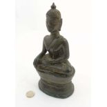 An Old east Asian bronze figure of a Buddha sat in lotus position, on a shaped base.
