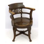 A 19thC oak office chair / captain's chair with pierced back splat and shaped cresting rail,