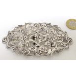 A silver plate buckle decorated with various mythical bird and beast and human mask decoration.