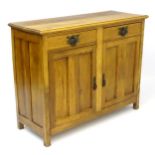 A 20thC continental style sideboard with panelled sides and two panelled doors above two short