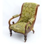 A Victorian open armchair with scrolling arms,