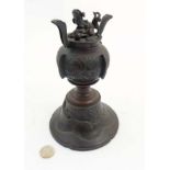 A Chinese patinated bronze coro with bell shaped base hang a four footed dragon in relief
