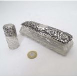 A cut glass dressing table pot with silver top having embossed decoration.