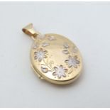 A 9ct gold locket with white gold foliate detail to front.