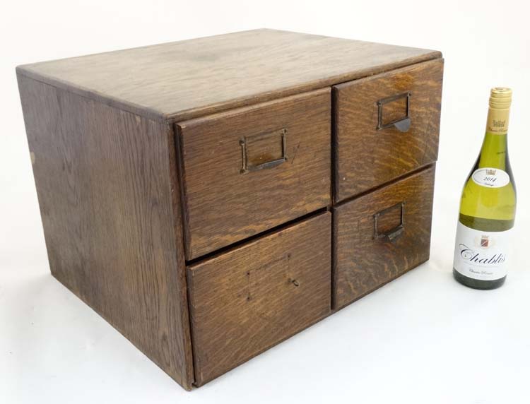 An early 20th C oak four drawer table top filing cabinet, with sliding sections within,