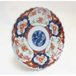 An Oriental Imari style plate with scalloped edges with stylized floral design to centre and other