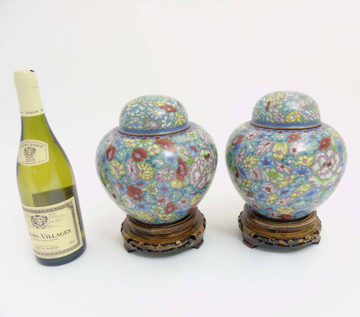 A pair of cloisonne gilt brass Ginger jars on stands with floral decoration.