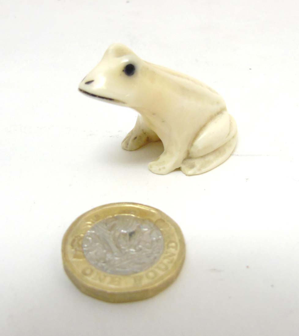 A Japanese Meiji period signed ivory netsuke formed as a frog with black eyes.