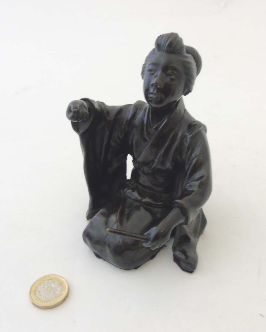 A 19thC Japanese Meiji patinated bronze in the form of a female kneeling.