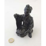 A 19thC Japanese Meiji patinated bronze in the form of a female kneeling.