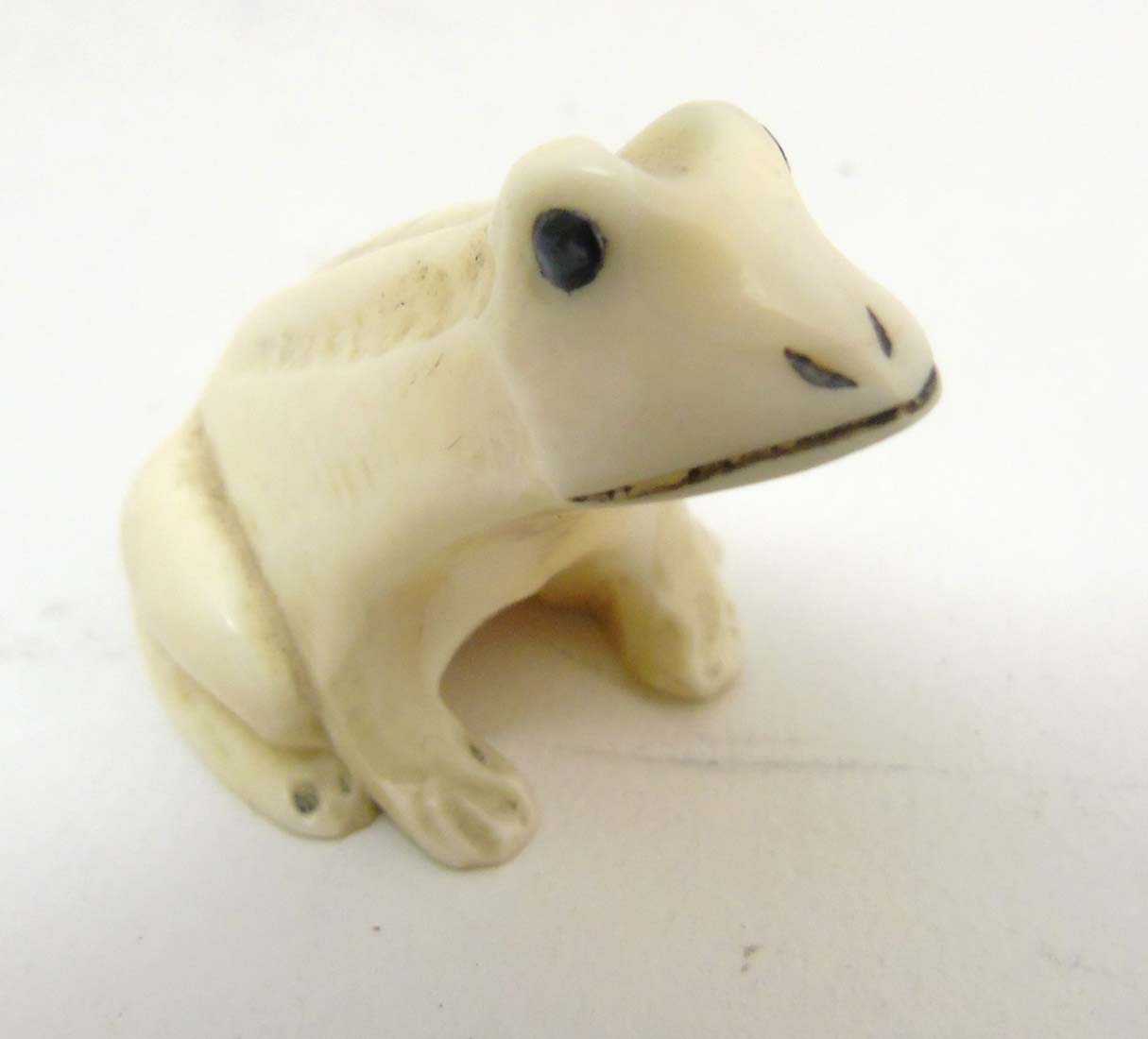 A Japanese Meiji period signed ivory netsuke formed as a frog with black eyes. - Image 3 of 8