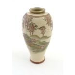 A Japanese Satsuma vase depicting a pagoda garden scene with wisteria decoration along to the top,