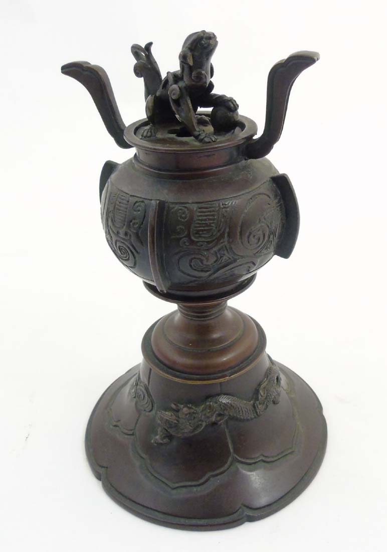 A Chinese patinated bronze coro with bell shaped base hang a four footed dragon in relief