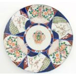 An Oriental charger having 6 panels of Japanese Imari decoration in iron red and blue around