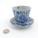A Chinese blue and white cup and saucer, the cup decorated with lotus flower head and scroll,