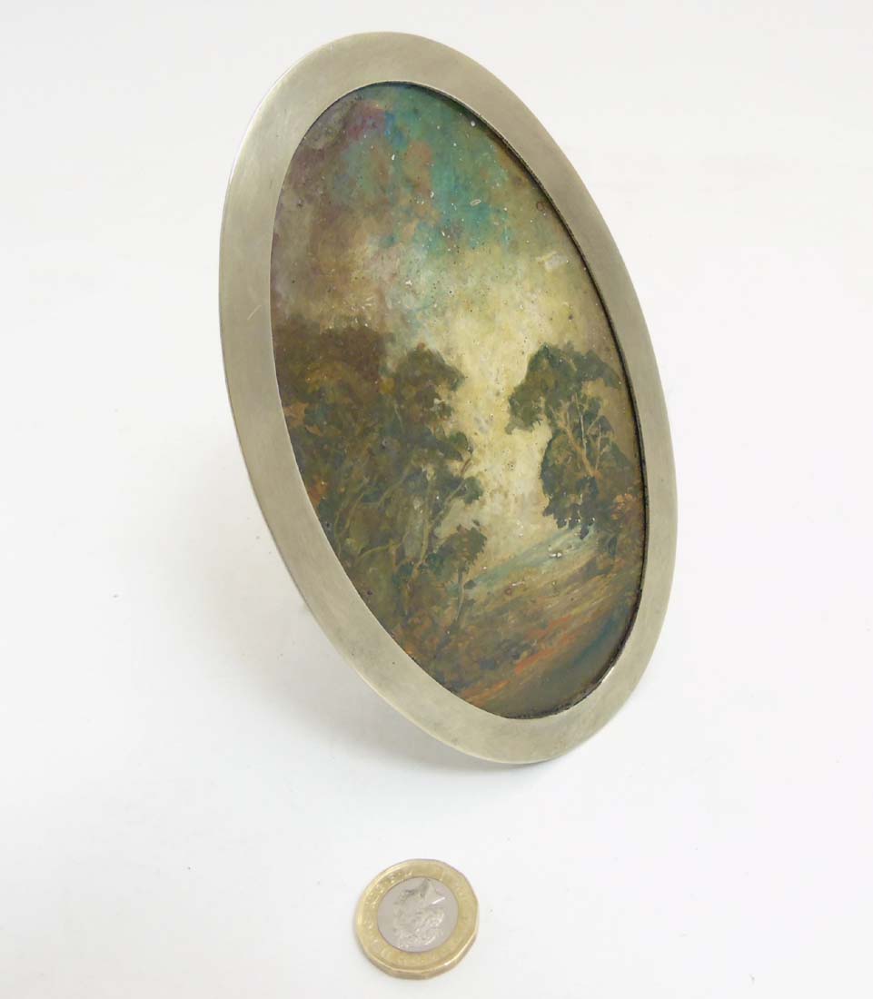 C.1900 Oil on card, landscape scene within an oval silver plate adjustable easel / strut frame.