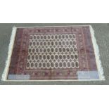 Rug Carpet : A late 20 thC machine made Bokhara rug with beige ground,