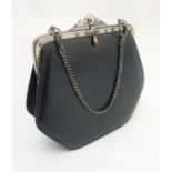 A ladies small black evening purse with silver coloured hardware and chain handle,