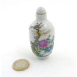 An Oriental Famille Rose snuff bottle depicting singing birds perched on cherry blossom branches
