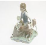 A Lladro 'Girl with Calf' figurine, makers mark to base,