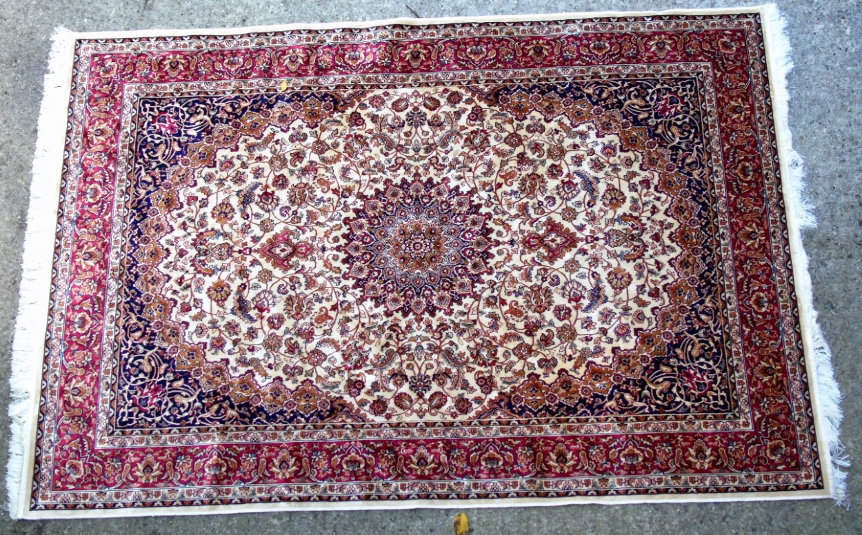 Rug / Carpet : Keshan machine made rug with beige ground, red border, in creams, red and navy.