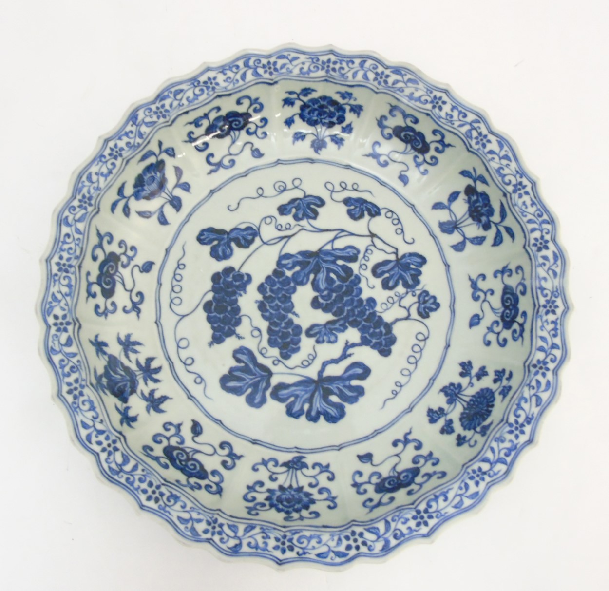 A Chinese blue and white 'Grape' dish / charger: A large Chinese charger with barbed rim,
