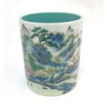 A Chinese famille rose brush pot painted in enamels depicting a continuous landscape scene of