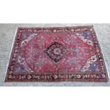 Rug / Carpet : With a red background and a floral and geometric design border and diamond central