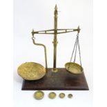 Brass balance shop scales on a wooden base with 4 various old wights including a Victorian 8oz