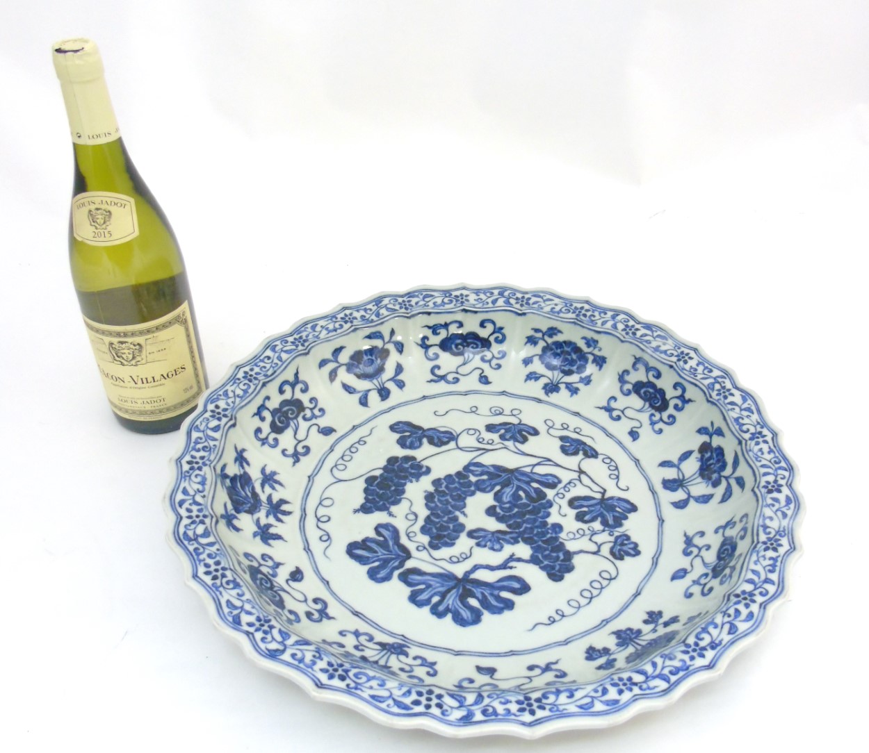 A Chinese blue and white 'Grape' dish / charger: A large Chinese charger with barbed rim, - Image 6 of 9
