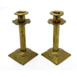 Art Nouveau : a pair of embossed brass candlesticks with square weighted bases,