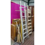 A collection of long hand tools, ladders etc.