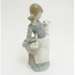 A Lladro 'girl with lamb and basket' figurine, makers mark to base,