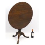 A mid 18thC oak tilt top tripod table with a tapering turned pedestal and wrythen turned