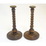 A pair of double twist solid turned wooden candlesticks with brass sconces 11 1/2" high