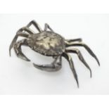 A white metal model of a crab, the body forming a small box with shell section hinging open.