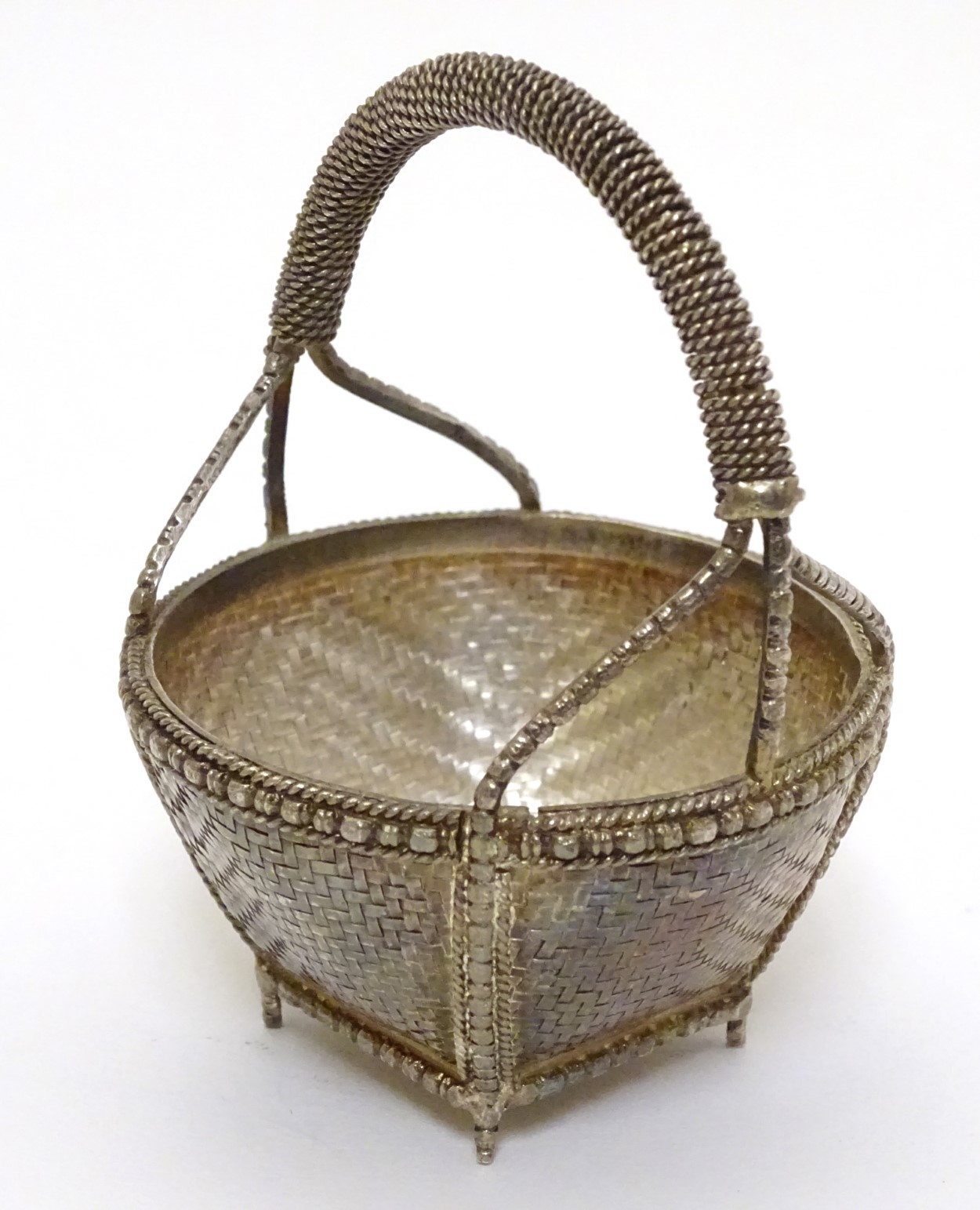 A small white metal basket with basket weave and gilt decoration. Possibly Indian. Approx 3" high.