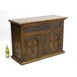 A 19thC Neo-Gothic oak small proportion sideboard with moulded and carved cornice overhanging one