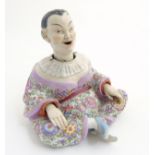 A Schierholz porcelain figure of a Chinese / Oriental man with nodding head and articulate hands,