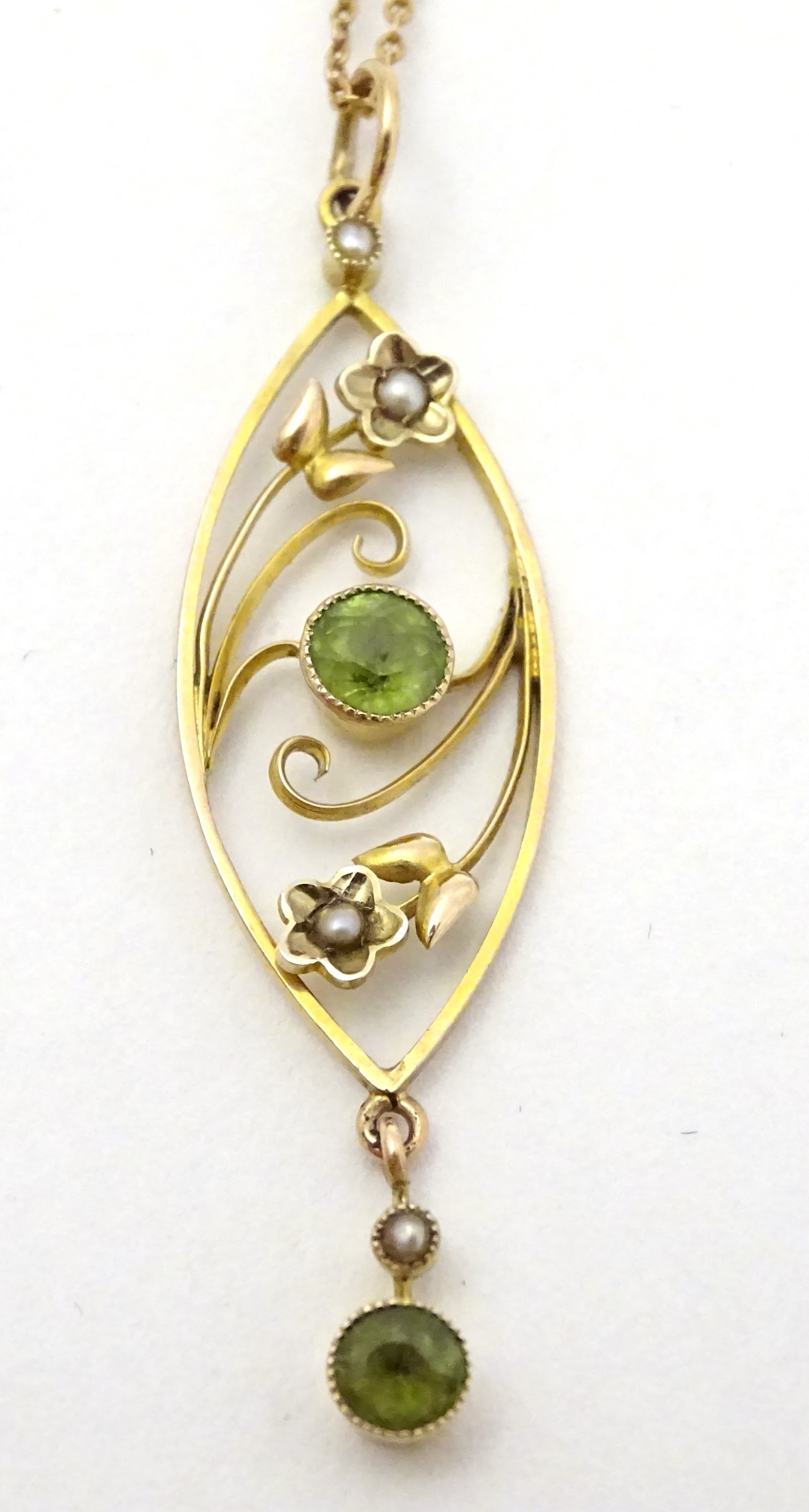 A yellow metal pendant and chain, the pendant set with peridot and seed pearls.