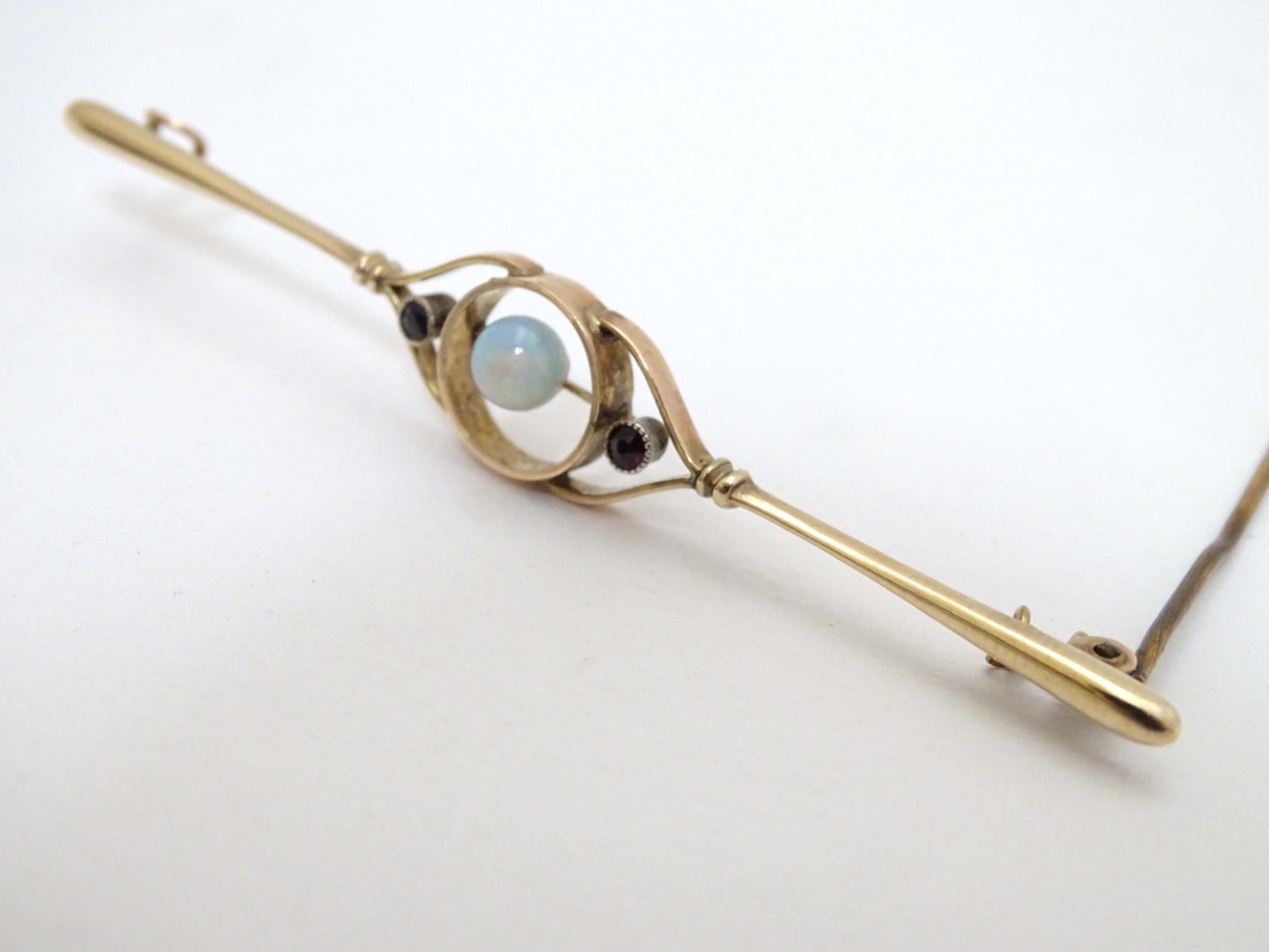 A 9ct gold brooch set with central opal flanked by garnets. - Image 2 of 8